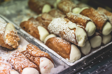 View of different traditional italian pastry candy desserts assorment, with cannoli, panna cotta, tartufo, amaretti, panettone, zeppole bomboloni, semifreddo, cartocci and others in Rome, Italy