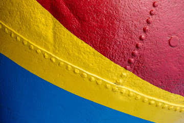 A close up abstract view of a colourful painted cement mixer