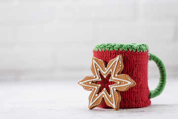 Knitted winter cup with gingerbread christmas cookies