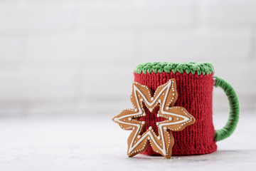 Knitted winter cup with gingerbread christmas cookies