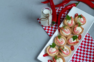 Tartlets with cream cheese and shrimp. Decorated with sprigs of dill and parsley.
