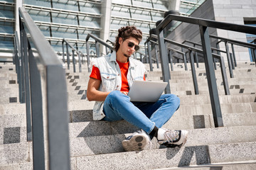 Young adult man using modern laptop outdoor