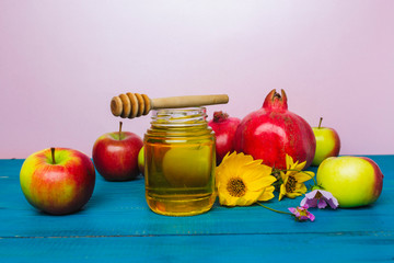 Jar of honey, apples and pomegranates on the table for the holiday of Rosh Hashanah