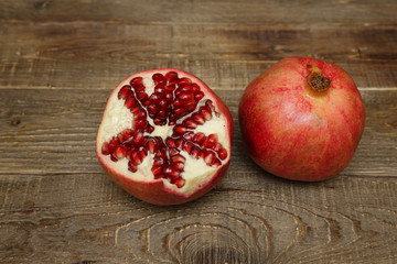  Fresh pomegranate and cut pomegranate on a wooden table with copy space for text. Healthy fruits,...