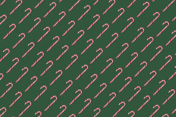 Festive christmas red and white candy canes isolated on green christmas background.