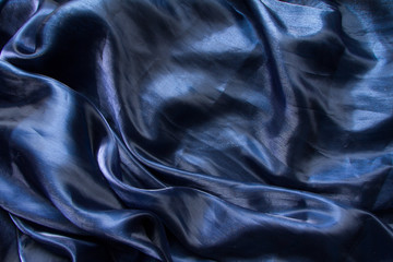 Background fabric folds dark blue tulle or organza, selective focus