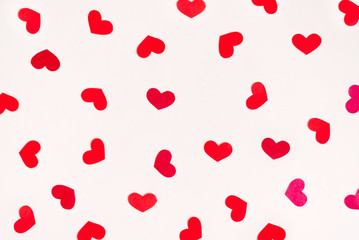 Red hearts are scattered in a chaotic order on a white background. Valentine's day holiday card