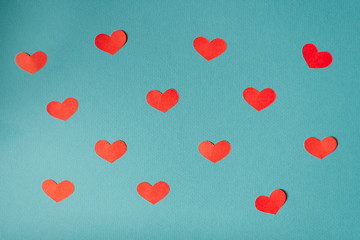 Fototapeta na wymiar Romantic Valentine's day background, cute hearts flat lay, minimalist banner Wallpaper design. Red paper cut hearts on blue background