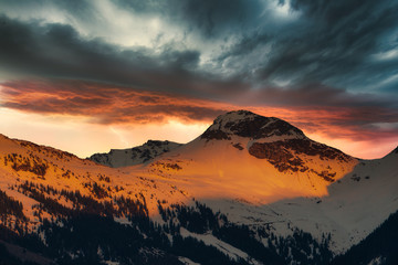 schneebedeckte Berge mit Gewitterwolken und Blitz