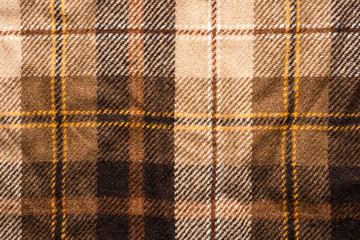 Brown checked fabric. Scottish wool. Fabric for coat plaid suit. Close-up. Background