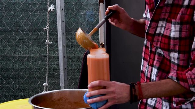 Food Vendor Fills Bottle with Homemade Sauce