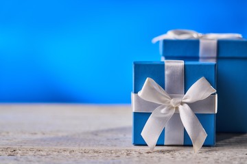 Blue gift box on white wooden table.
