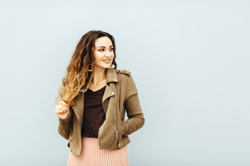 Pretty young sexy fashion sensual woman posing on white wall background dressed in fashionable style jacket pink powdery skirtoutfit,Stylish dark haired girl hipster in clothes.White background,not