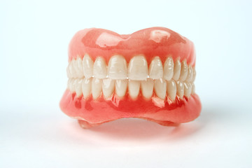 Diagnosis prosthetics treatment concept. Artificial teeth and magnifying glass