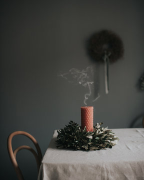 Blown out candle with wreath on table