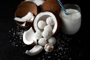 cooked coconut milk candies on a black dark background, ingredients for a dessert with coconuts, a sweet product with coconut flakes