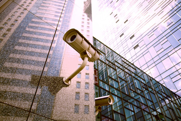 CCTV camera on the wall of the skyscraper. Private property protection. Camera in office building. Modern security technology. - 309271653