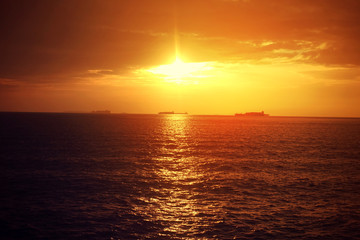 Romantic sunset over the Aegean sea with beautiful golden colours and clouds as seen from cruising yacht in Cyclades isalands, Greece