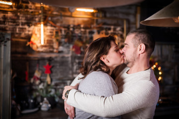 Fototapeta premium Portrait of a young couple in the living room at Christmas.