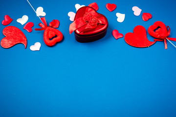 Red heart with a gift to Valentine's Day on a beautiful blue background. Heart pendant. Space for...