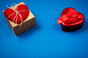 Red heart with a gift to Valentine's Day on a beautiful blue background. Heart pendant. Space for...