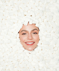 Smiling female amidst white marshmallows