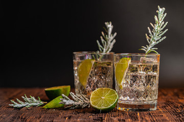 Gin and tonic with lime and ice on wooden table. Ideas of winter drinks