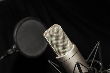 Microfono de condensador en estudio con antipop y fondo negro