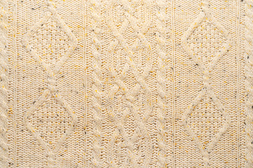 The texture of a knitted beige sweater. Beautiful textured arana patterns. Background. Copy space