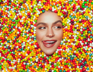 Excited female licking lips amidst sweets