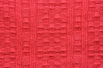 The texture of a knitted sweater. Red pattern. Facial surface. Background. Copy space