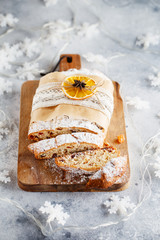 Holiday baking. Christmas cake. Stollen is fruit bread of nuts, spices, dried or candied fruit, coated with powdered sugar. It is traditional German bread eaten in the Christmas season. New year