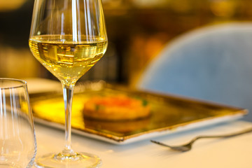 detail of glass of white wine with risotto dish in refined Italian restaurant - 309275200