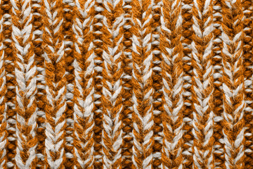 The texture of a knitted sweater. Brown white mottled pattern. Facial surface. Background. Copy space