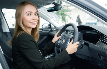 Happy female client sitting in new comfortable automobile