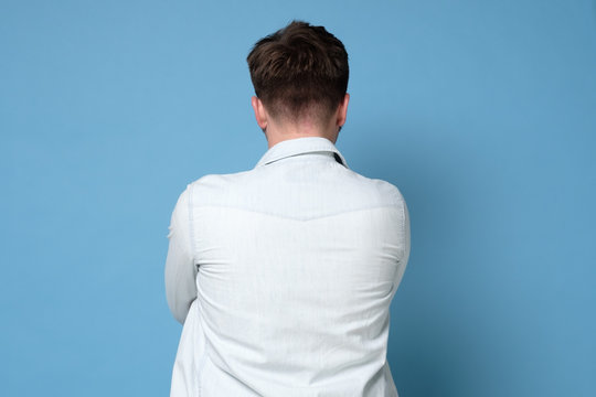 Caucasian young man standing alone isolated from rear view.