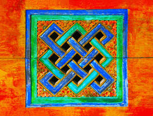unlösbarer Knoten leuchtend blau und grün, Hintergrund in glühenden orange, Schnitzerei aus Holz...