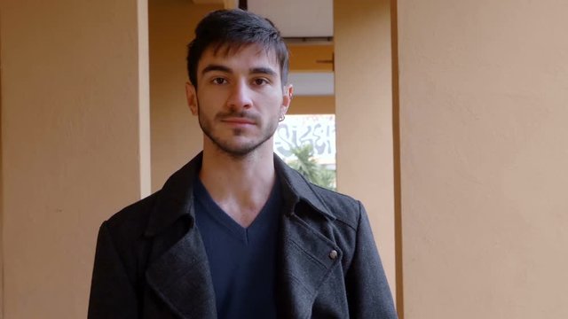 proud and confident  young man walking outside a building