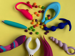 Many sex toys. Vibrators and anal plugs on a yellow background. Useful for sex shop or adults