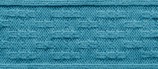 The texture of a knitted sweater. Blue pattern. Facial surface. Background. Copy space