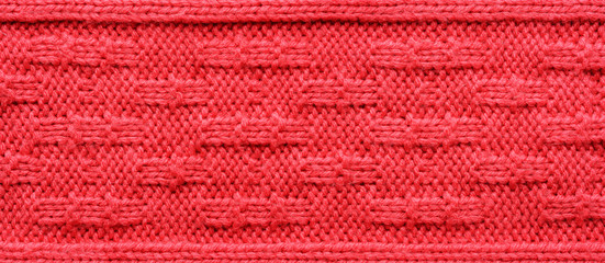 The texture of a knitted sweater. Red pattern. Facial surface. Background. Copy space
