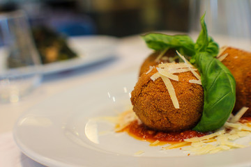 dish with fried eggplant balls, stuffed with provola cheese, basil and tomato sauce in a typical Italian restaurant