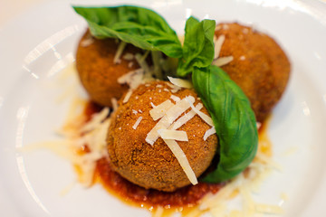 dish with fried eggplant balls, stuffed with provola cheese, basil and tomato sauce in a typical Italian restaurant