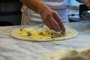 4 cheese pizza preparation with gorgonzola, smoked provola cheese, buffalo mozzarella and pecorino, in a typical Italian pizzeria - 309278449