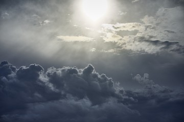Beautiful scenery of white puffy clouds under bright sun rays