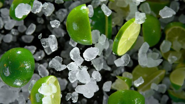 Super Slow Motion of exploding crushed ice with limes towards camera, close-up