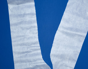 torn piece of white parchment paper on a blue background