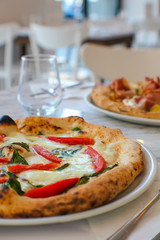 pizza with tomato slices San Marzano and buffalo mozzarella in an Italian pizzeria - 309278697