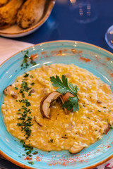 saffron risotto dish with porcini mushrooms, parsley and chilli pepper - 309278800