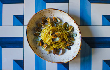 top view of fresh bronze-drawn spaghetti and a sprinkling of parsley and Cilento oil in a luxury...